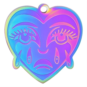 Macro detail of iridescent heart pendant with engraved eyelashes and teardrop pattern