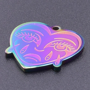 Macro shot of rainbow titanium plated heart pendant with engraved eye art details