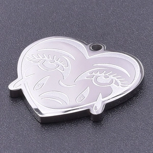 Macro detail of a heart-shaped stainless steel pendant with personalized face engraving