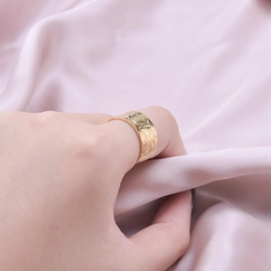 Minimalist gold stainless steel wide ring featuring unique irregular hammered texture on silk