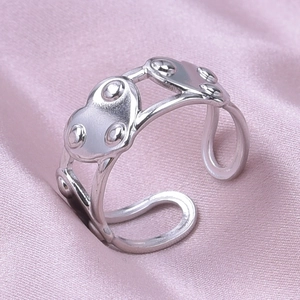 Macro detail of silver adjustable open ring with heart shapes and bead texture