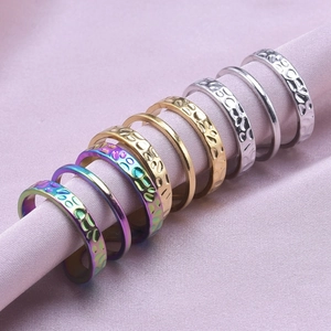 Detail of three-color stainless steel rings with smooth and hammered textures on silk