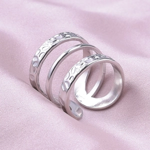 Detail of silver 304 stainless steel triple-layered ring with hammered texture on pink silk