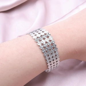 Détail d'un large bracelet argenté à texture martelée porté par un mannequin