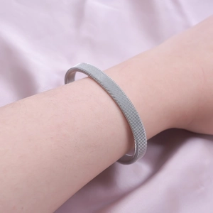 Detailed macro view of silver Milanese mesh woven stainless steel open cuff bracelet