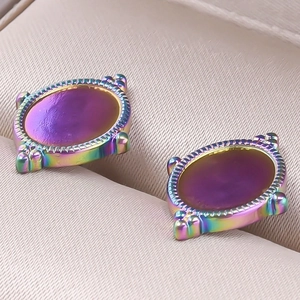 Gros plan de boucles d'oreilles ovales en acier inoxydable avec miroirs violets et arc-en-ciel