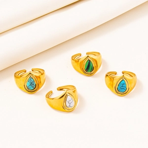 Detailed macro of four adjustable gold-plated stainless steel rings with colorful gemstones