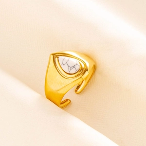 Detailed close-up of a gold adjustable ring with a teardrop-shaped white turquoise stone