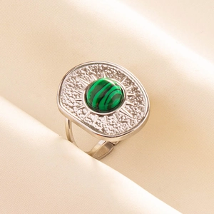 Macro detail of retro stainless steel ring with green malachite and sunburst texture