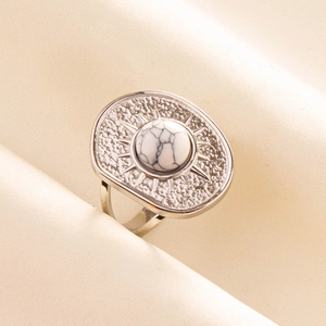 Detailed macro view of silver steel ring with starburst pattern and marble stone inlay