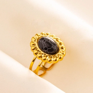 Détail macro d'une bague vintage dorée en acier inoxydable avec pierre de marbre