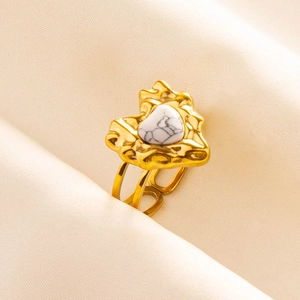 Close-up of vintage heart ring with white marble stone and gold lava texture band