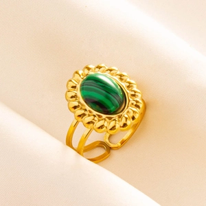 Détail de bague vintage en acier 304 avec pierre verte ovale et lunette dorée florale