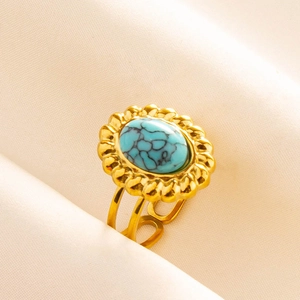 Détail d'une bague vintage dorée avec pierre turquoise ovale et anneau réglable