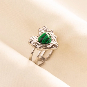 Detail of a 304 stainless steel heart-shaped malachite open ring on beige fabric background