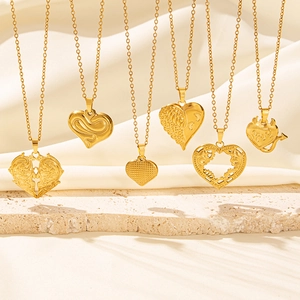 Vari stili di collane con ciondolo a cuore placcate oro 18k su sfondo di seta beige
