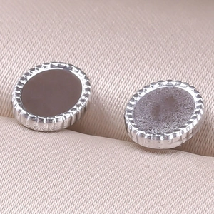 Gros plan de boucles d'oreilles en acier inoxydable 304 avec bords gravés et centre noir