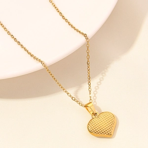 Dettaglio di una collana a cuore placcata oro 18k con trama a griglia testurizzata