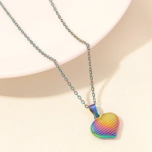 Dettaglio di un ciondolo a cuore arcobaleno con trama a griglia su catena fine