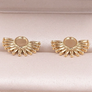 Détail de bases de boucles d'oreilles en acier doré dans un écrin couleur champagne