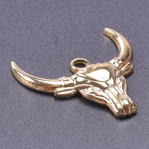 Detailed view of polished 18k gold plated stainless steel bull head pendant with loop