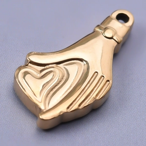 Vista macro detallada de un colgante de mano con corazón de acero inoxidable 304 dorado