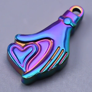 Primer plano de un colgante de acero inoxidable arcoíris con forma de mano y corazón