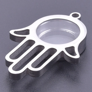 Macro view of silver Hamsa locket with transparent window and polished steel finish