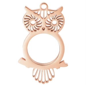 Close-up of rose gold owl pendant featuring hollow spiral patterns and a circular frame