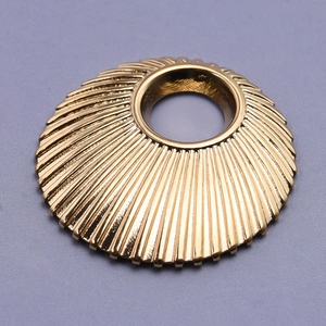 Macro view of a round gold 304 stainless steel shell pendant with sunburst texture