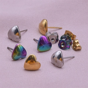 Detail view of heart-shaped stainless steel stud earrings in gold, silver and iridescent