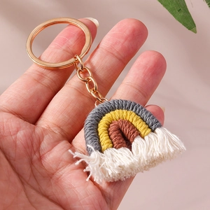 Macro view of handmade macrame rainbow keychain with cotton tassels and gold metal ring