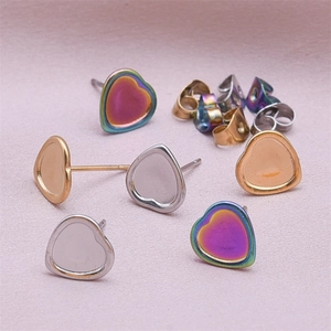 Macro detail of heart-shaped earring bases and butterfly backs in three metallic finishes