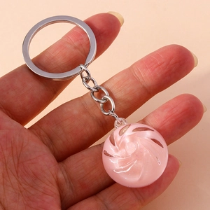 Detail shot of a pink crystal swirl keychain with a silver metal ring and chain