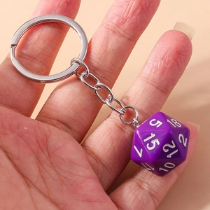Detail showing a purple 20-sided D20 dice keychain with white numbers and silver metal ring
