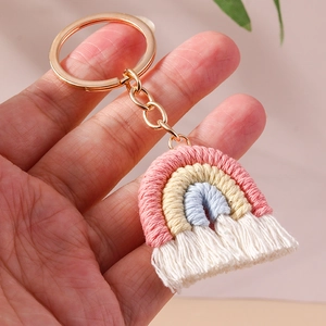 Macro detail of handmade macrame rainbow keychain with pastel cotton cords and gold metal ring