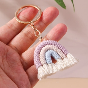 Detail of handmade knit rainbow keychain with purple cotton cords and beige tassels