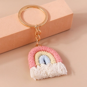 Detail of handmade knit rainbow keychain with soft cotton tassels and golden metal ring