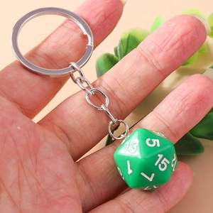 Close-up of green d20 dice keychain with silver metal ring held in hand for scale