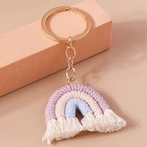 Detailed macro view of handmade woven rainbow keychain with cotton tassels and gold ring