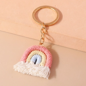 Close-up of handmade woven rainbow keychain with three-color cotton cord and fringe