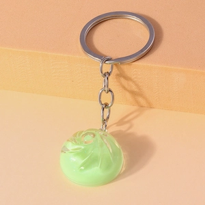 Macro detail of a light green translucent crystal dumpling keychain with silver ring