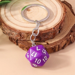 Macro detail of a purple D20 dice keychain featuring white numbers on a wood surface