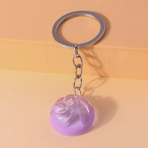 Detail of a purple translucent glitter baozi keychain with a polished silver keyring