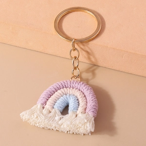 Detailed close-up of handmade rainbow keychain with purple, cream and blue cotton ropes