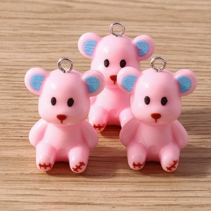 Macro detail of three pink resin bear charms with blue ears and silver metal loops