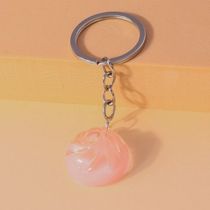 Macro detail of a translucent pink spiral resin pendant charm with silver keychain ring