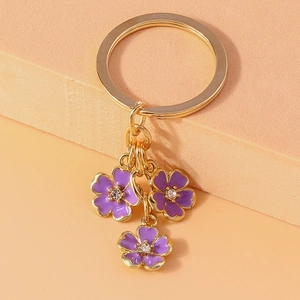 Creative Chinese style keychain featuring three purple enamel five-petal flower pendants