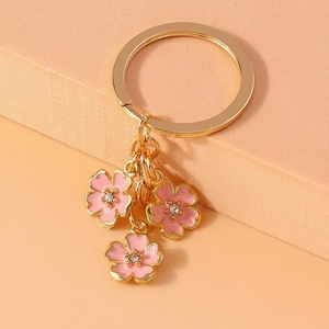 Detailed close-up of pink enamel cherry blossom charms with sparkling rhinestones