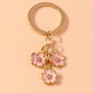 Detail of pink enamel cherry blossom keychain with gold alloy finish and tiny rhinestones